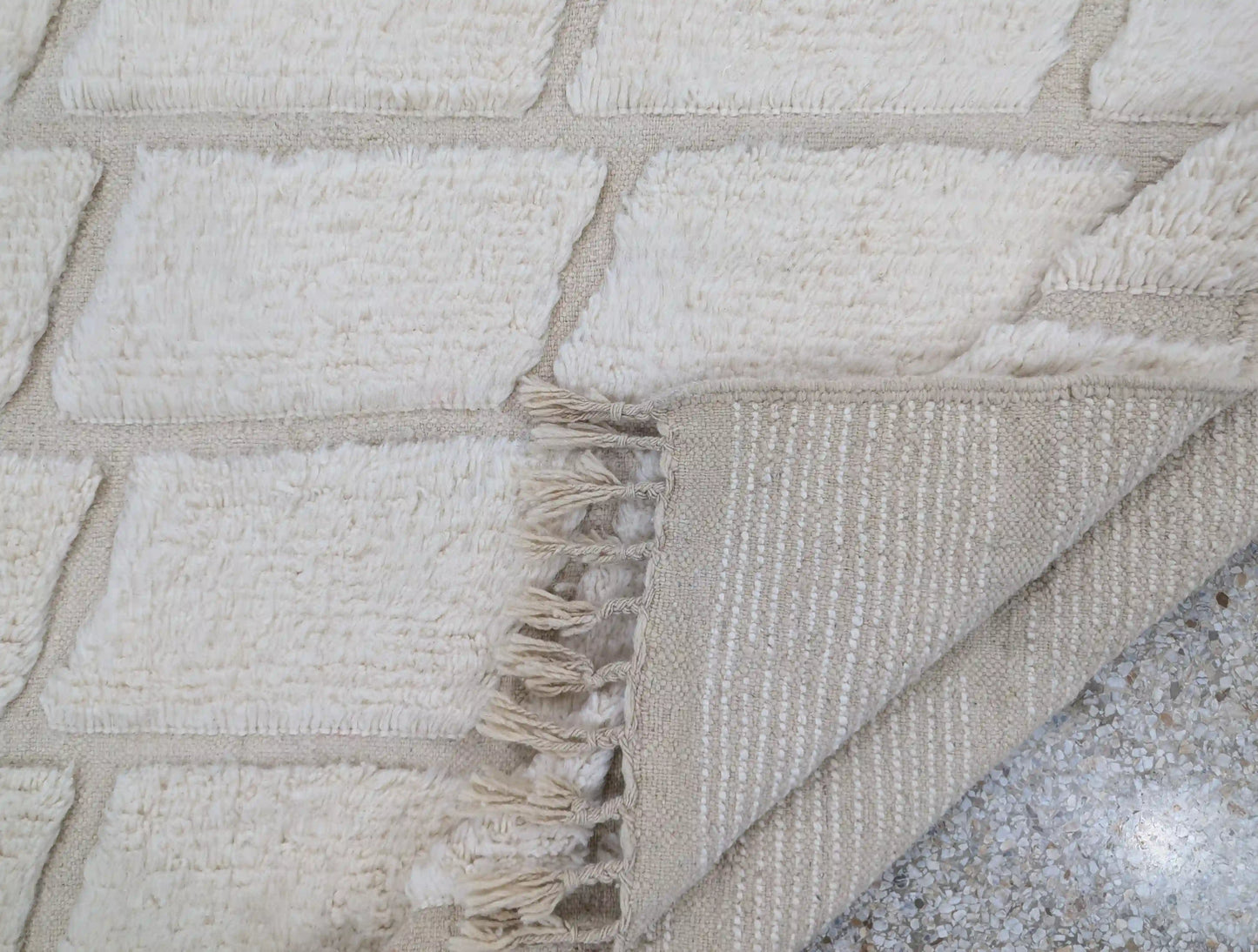 Vue arrière d’un tapis Beni Ouarain blanc, montrant les finitions du tissage artisanal