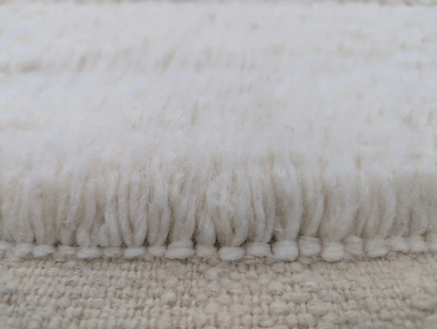 Texture douce et épaisse de la laine naturelle d’un tapis Beni Ouarain blanc fait main