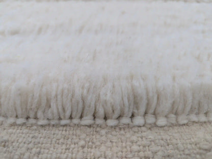 Texture douce et épaisse de la laine naturelle d’un tapis Beni Ouarain blanc fait main