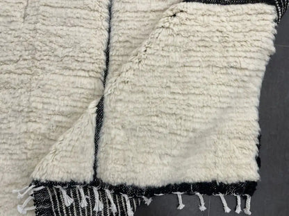 Envers du tapis Beni Ouarain, tissage traditionnel marocain en laine, motifs noirs sur fond blanc.