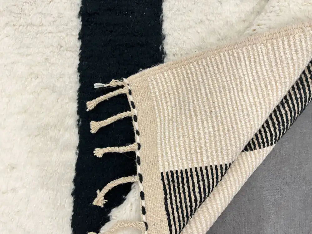 Dos du tapis berbère en laine, rayures bleues et blanches, preuve d’un tissage authentique.