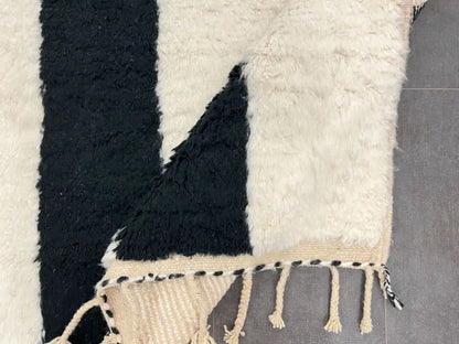 Revers du tapis berbère en laine avec motifs géométriques, montrant la qualité du tissage.