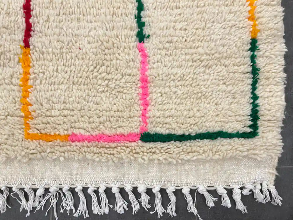 Franges nouées à la main d’un tapis berbère moderne, finition soignée et authentique.