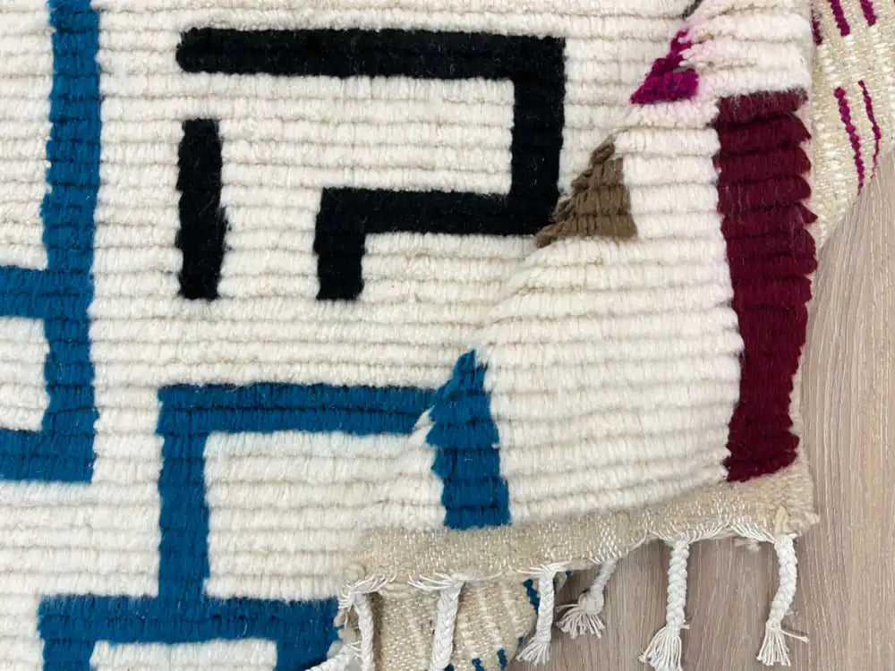 Tapis berbère en laine naturelle plié, fabrication artisanale marocaine traditionnelle