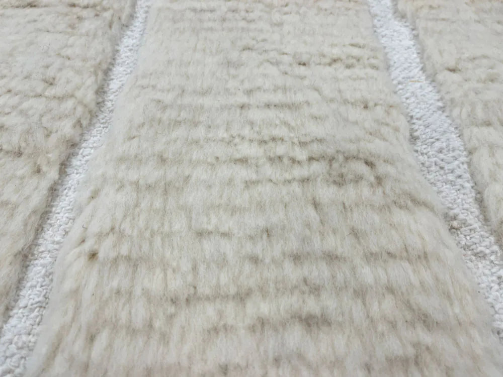 Gros plan sur laine épaisse d’un tapis berbere pas cher, texture moelleuse artisanale