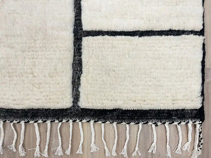 Franges du tapis Blanc Beni Ouarain nouées à la main, authenticité et finition haut de gamme pour décoration chic.