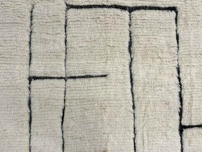 Tapis Blanc Beni Ouarain en laine naturelle avec motifs géométriques noirs, fait main au Maroc, parfait pour salon moderne.