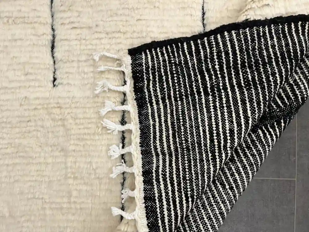 Détails du tissage en noir et blanc du tapis Blanc Beni Ouarain, pure laine, symbole du savoir-faire berbère.