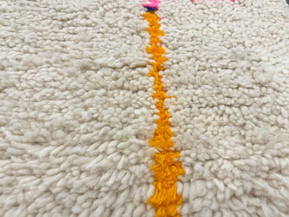 Zoom sur la texture épaisse d’un tapis en laine tissé à la main, design graphique marocain.