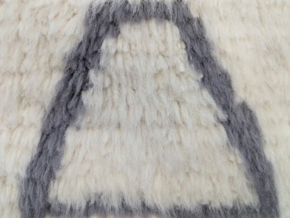 Zoom sur la texture épaisse d’un tapis en laine tissé à la main, design graphique marocain