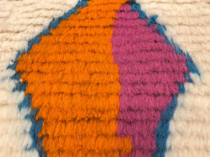 Gros plan sur la matière du tapis berbère en laine de mouton, texture épaisse et douce tissée à la main.