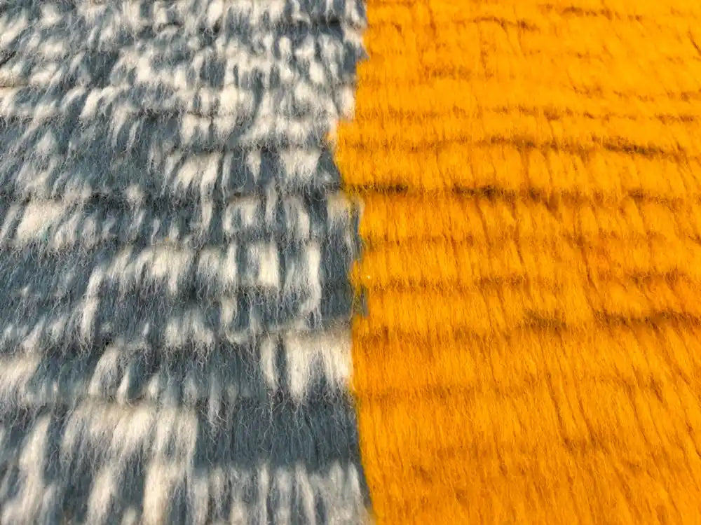 Gros plan sur la laine naturelle épaisse et douce du tapis berbère Azilal