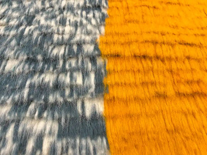 Gros plan sur la laine naturelle épaisse et douce du tapis berbère Azilal