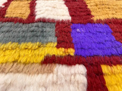 Gros plan sur la laine naturelle épaisse et douce du tapis berbère Azilal