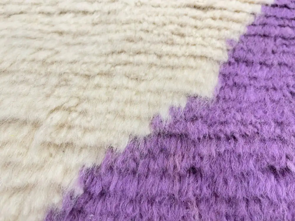 Gros plan sur la texture épaisse et douce de la laine naturelle du tapis berbère Beni Ouarain fait main.