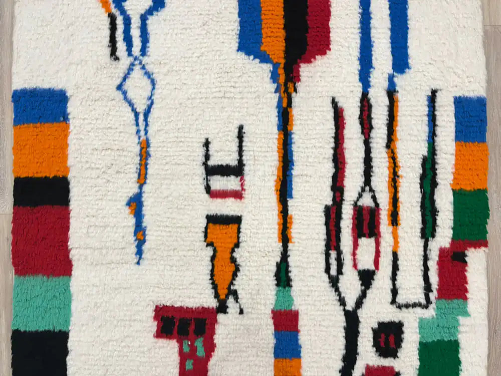 Gros plan sur le milieu du tapis Azilal montrant les motifs graphiques et les couleurs vives.