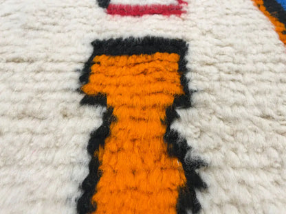 Zoom sur la laine épaisse et douce du tapis multicolore Azilal fait main, texture naturelle et confortable.