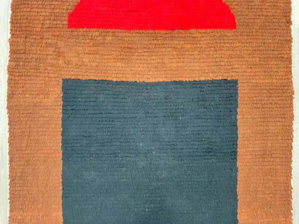 Gros plan sur le centre du tapis Beni Ouarain montrant les motifs géométriques noirs sur fond clair.