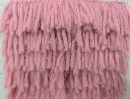 Gros plan sur la texture épaisse et naturelle d’un tapis berbère en laine